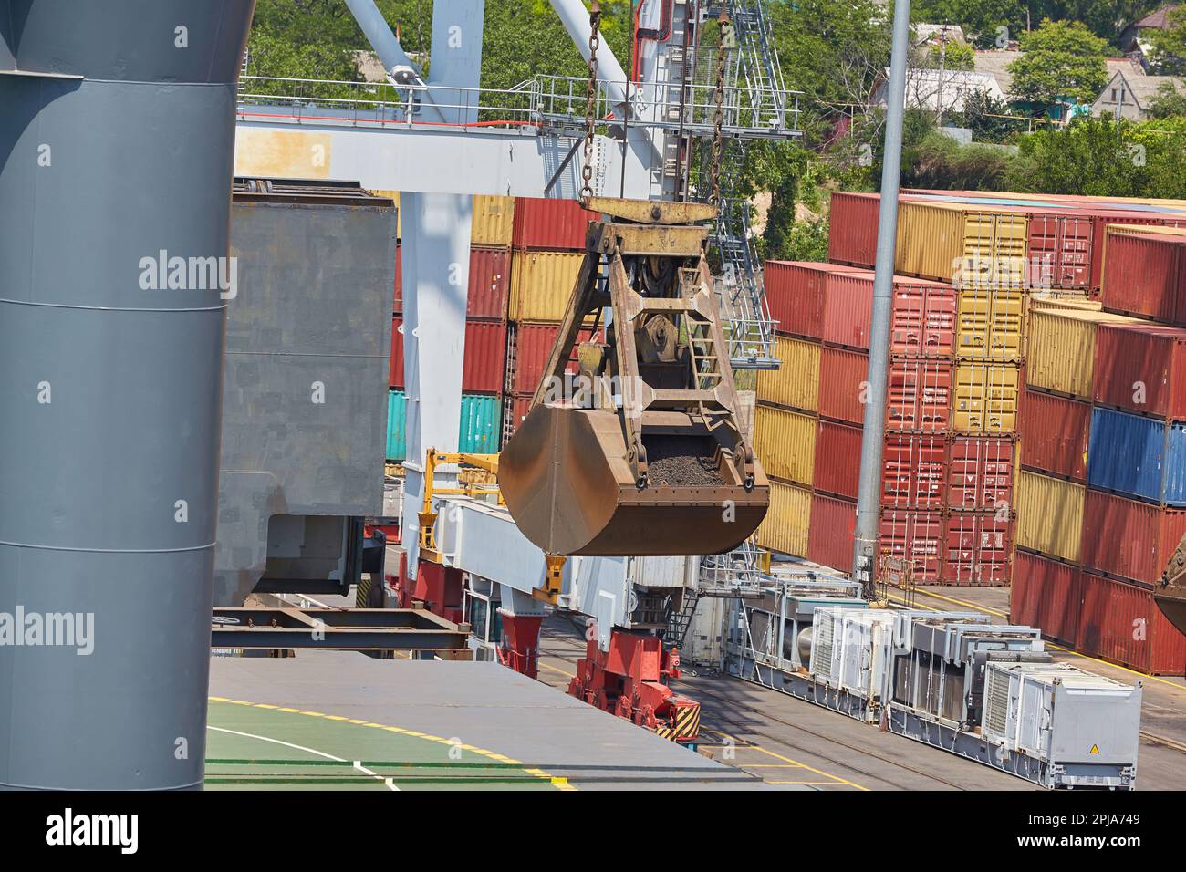 A crane bucket in the port above the bulk carrier deck. Stock Photo