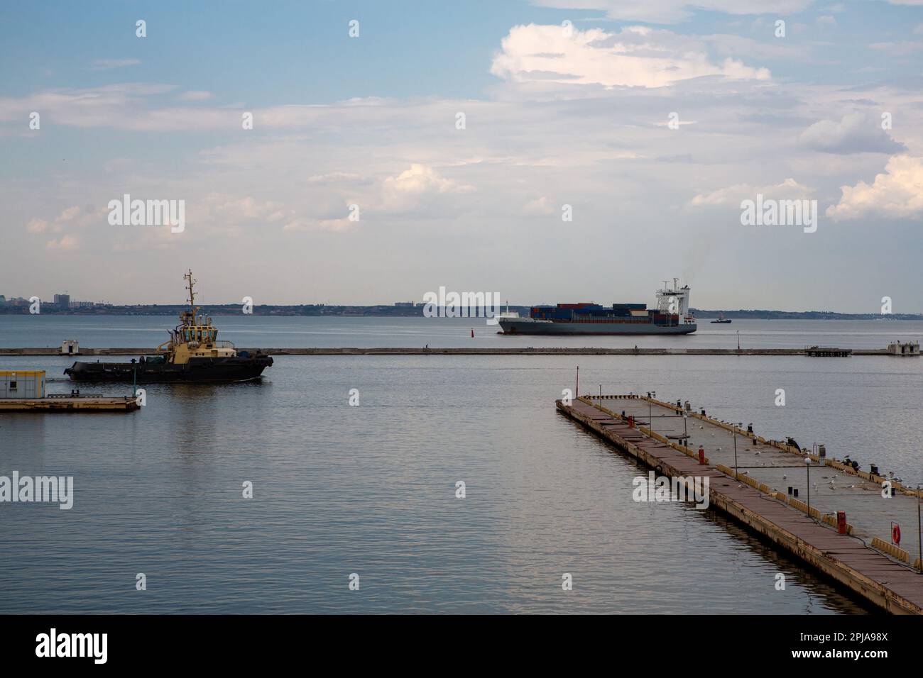 Tugboat in port with ccontainer ship on backgground Stock Photo