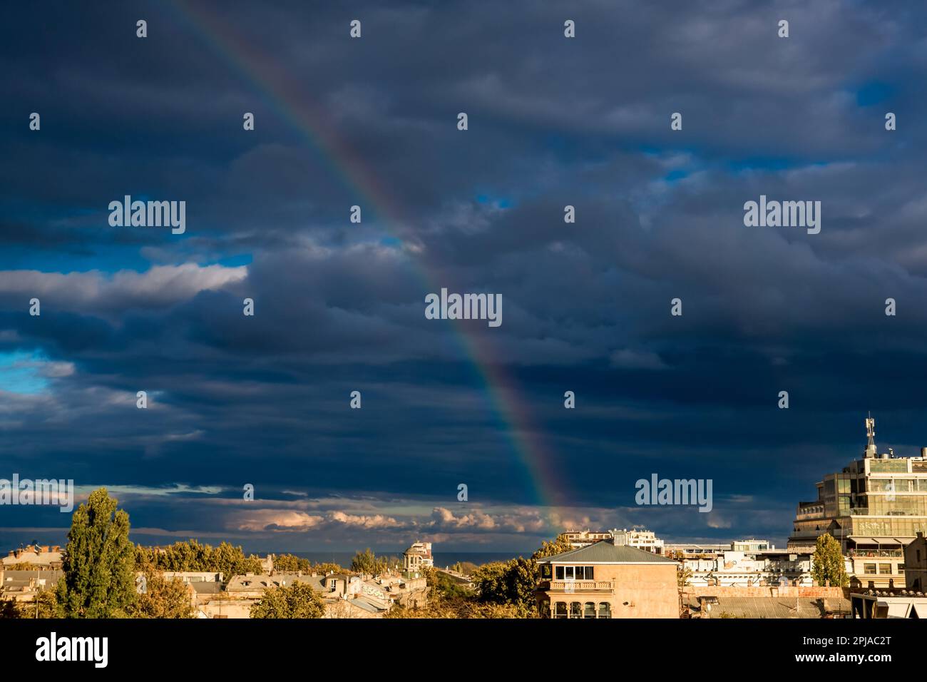 A rainbow after a thunderstorm against a dark blue sky Stock Photo - Alamy