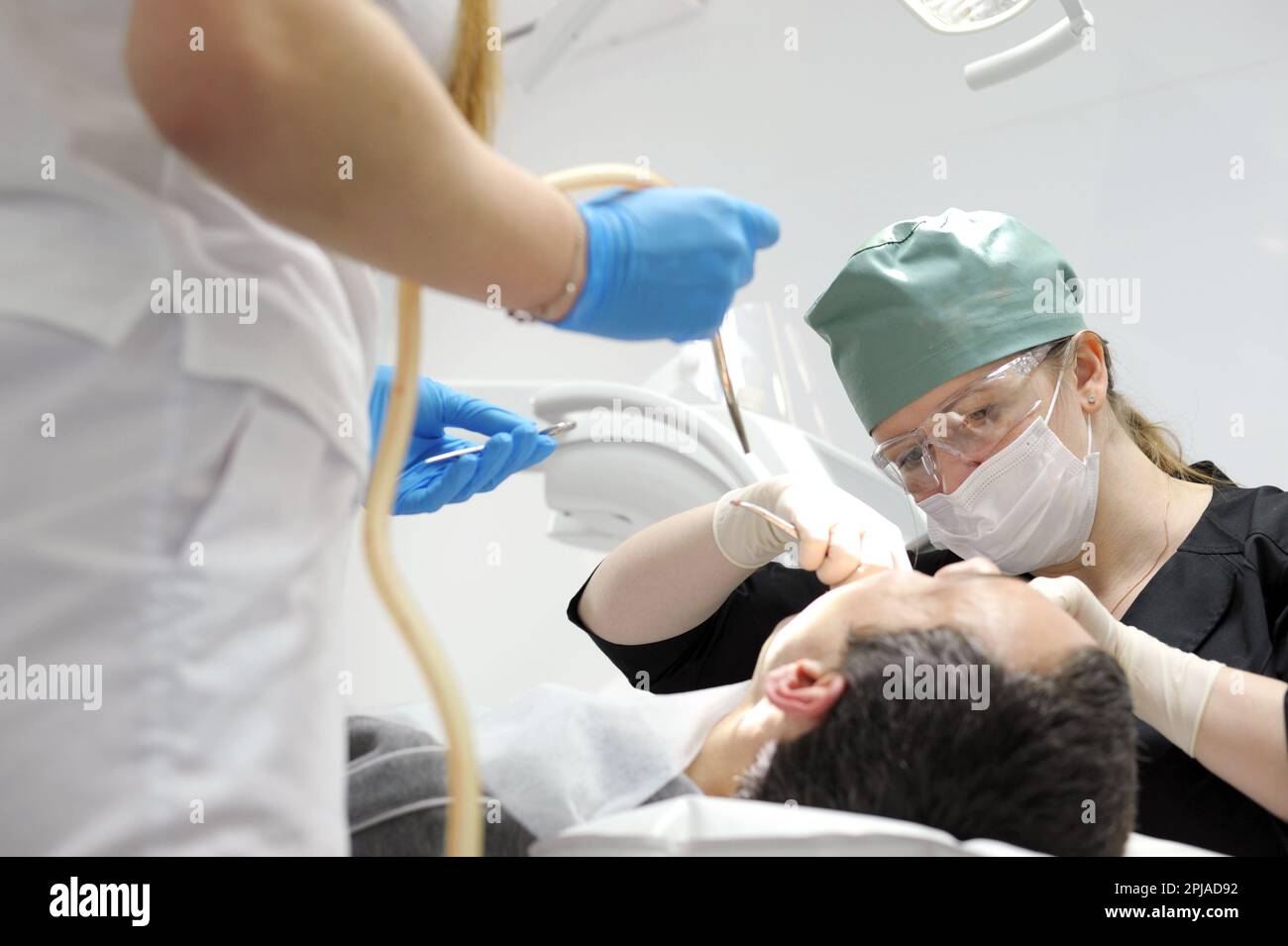 remove a tooth Male Dentist remove tooth of man patient using forceps