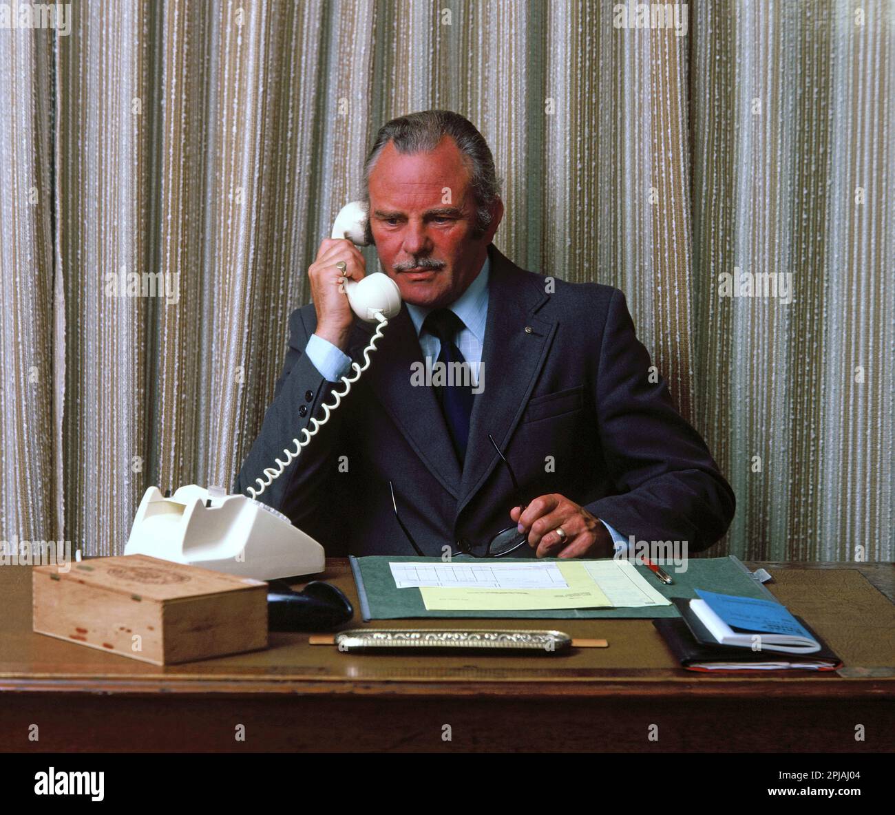 Business. Managing Director at desk using vintage telephone Stock Photo