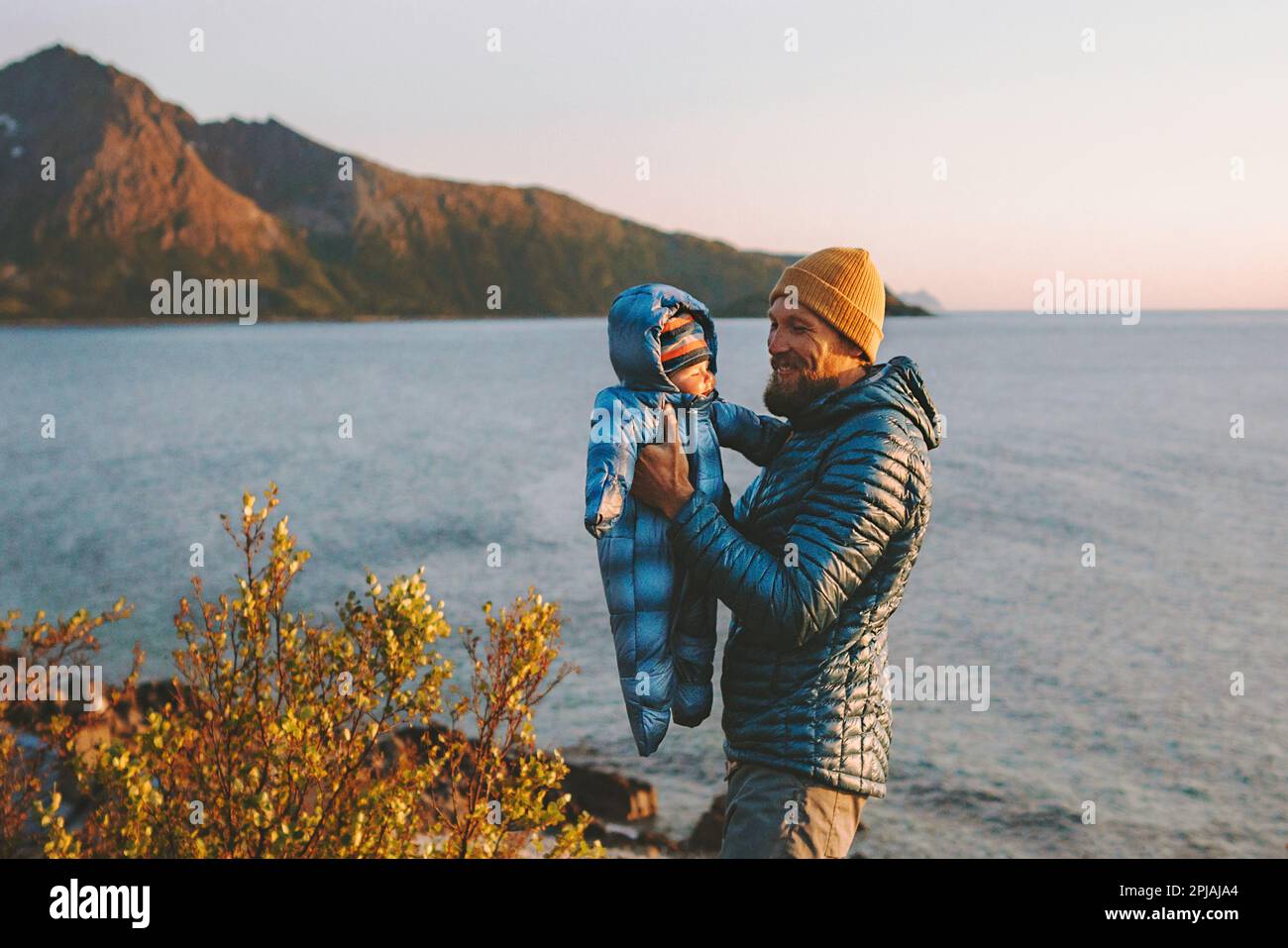 Father playing with baby outdoor family vacation lifestyle travel in Norway man with infant kid walking together autumn season Stock Photo