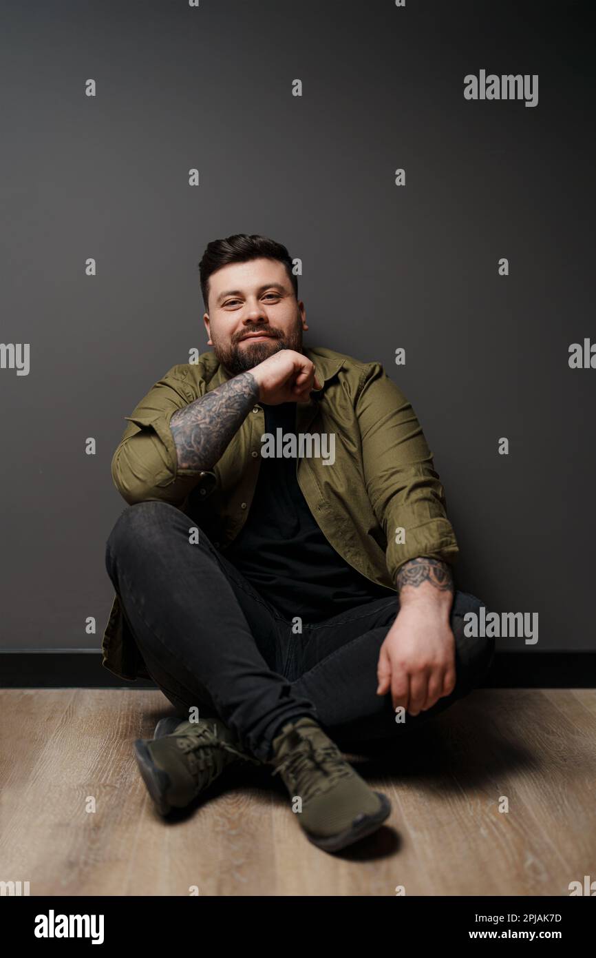 Content man sitting on floor with crossed legs Stock Photo - Alamy