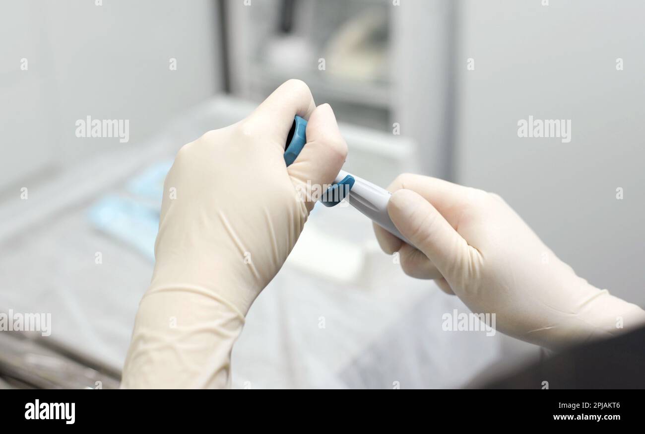 hands of doctor hold key nozzle and piezoelectric scaler removal of