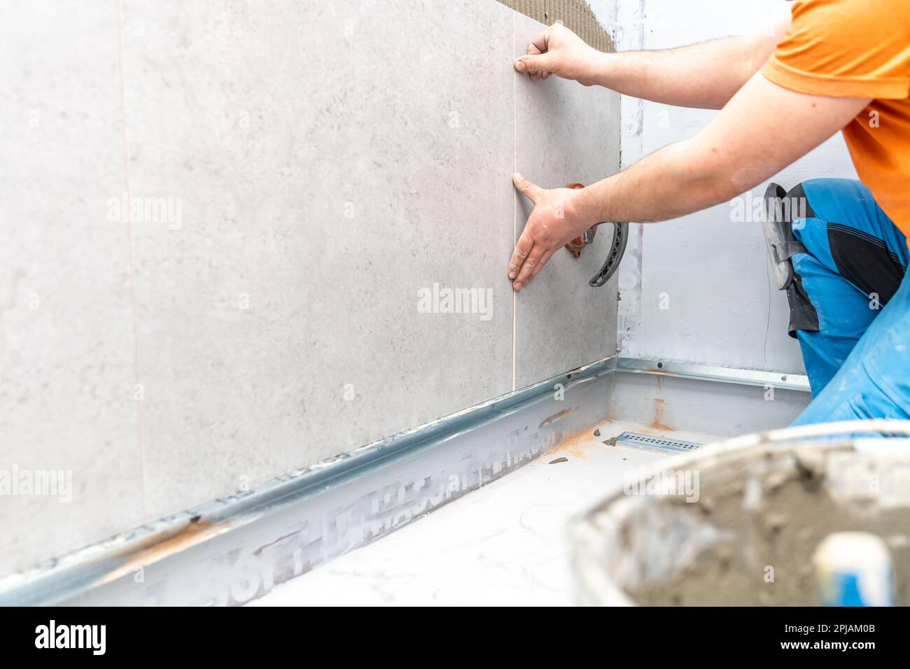 installation of large format tiles on the wall by a craftsman Stock Photo