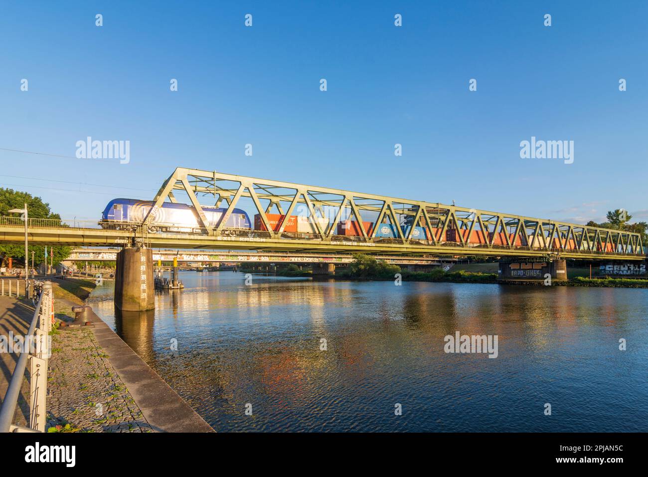 Bremen: river Weser, promenade Weserbahnhof-Promenade, bridge Eisenbahnbrücke, cargo train in , Bremen, Germany Stock Photo