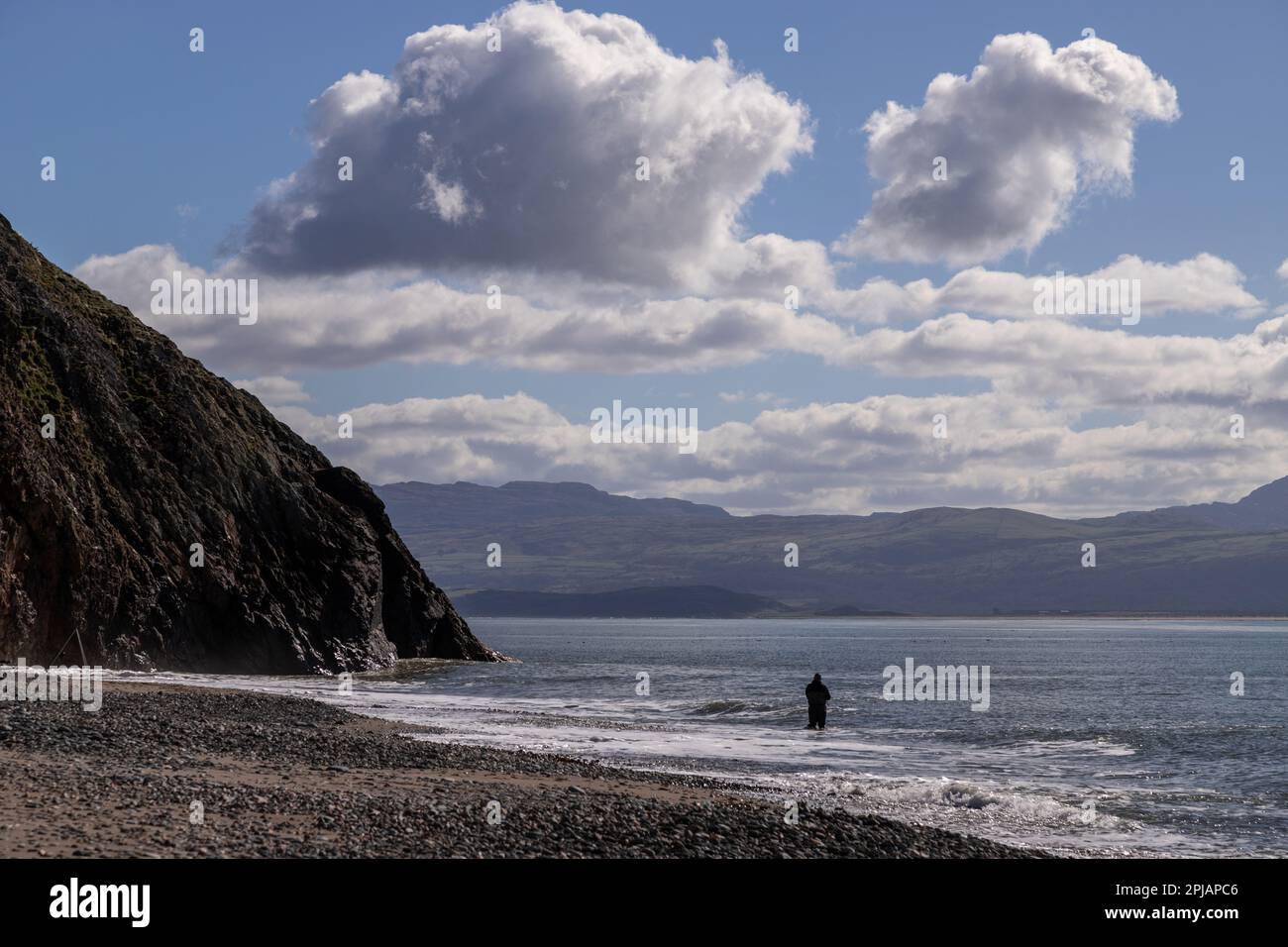 Angler in the surf at Criccieth beach, North wales coast Stock Photo