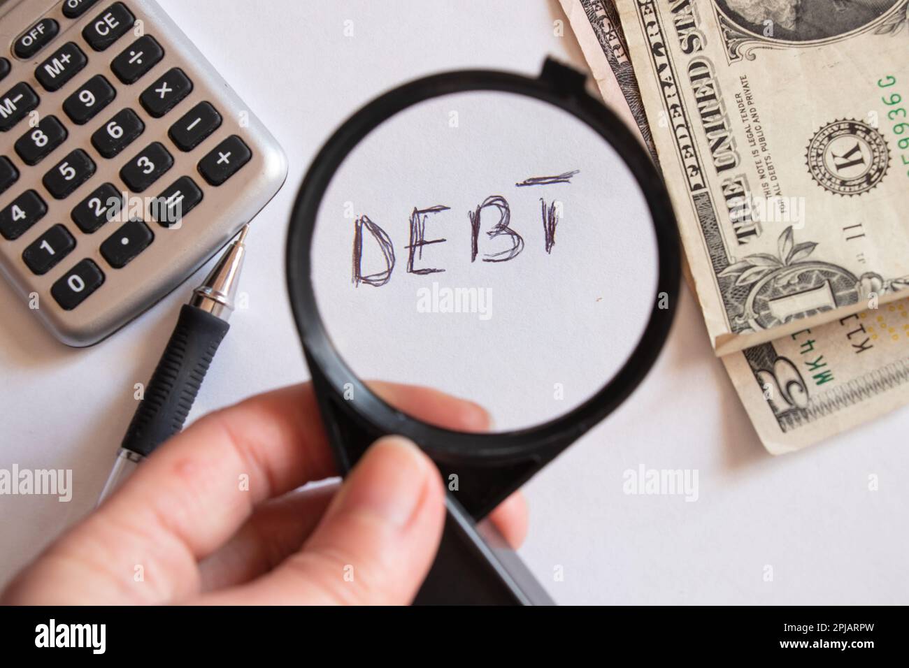 dollars and magnifying glass on the table, financial debt Stock Photo