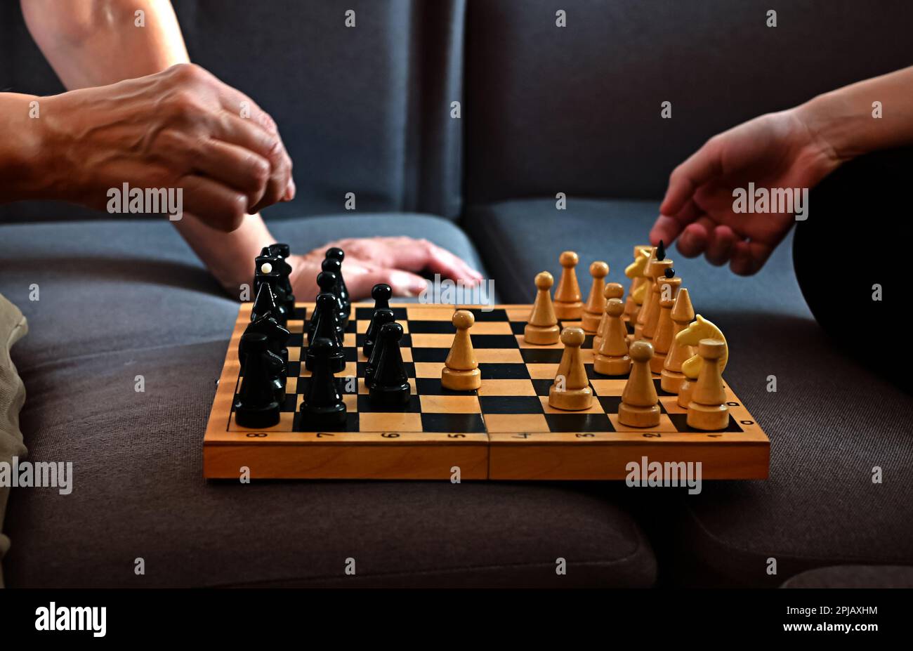 Grandmother playing chess with her granddaughter at home. Strategy and planning concept. Activities for seniors, elderly active lifestyle, older peopl Stock Photo