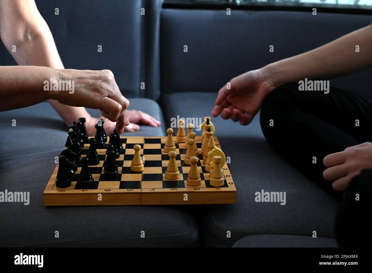Grandmother playing chess with her granddaughter at home. Strategy and planning concept. Activities for seniors, elderly active lifestyle, older peopl Stock Photo