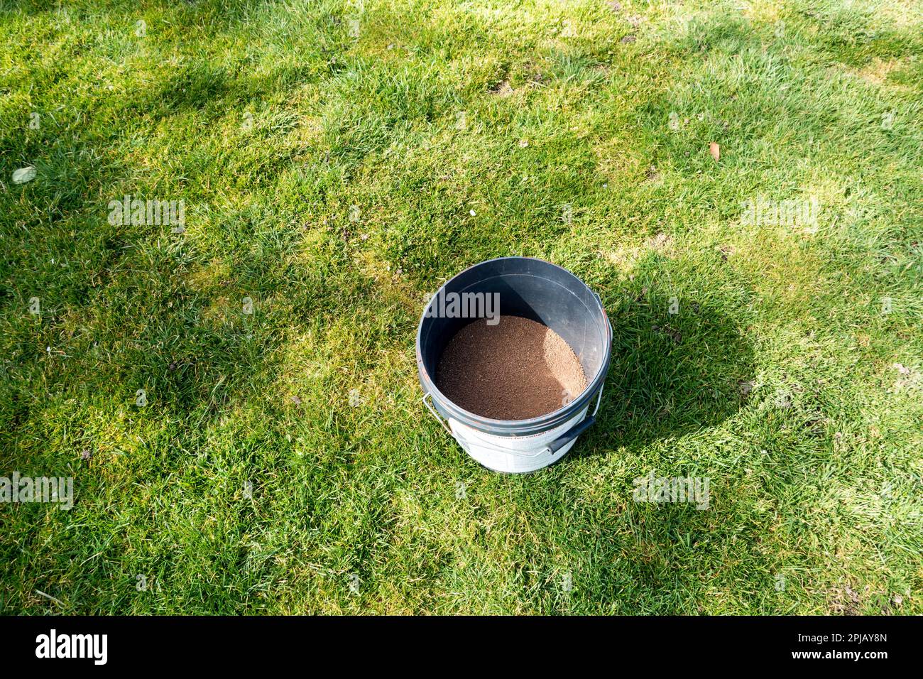 Lawn feed fertilizer in a plastic bucket placed in lawn Stock Photo Alamy