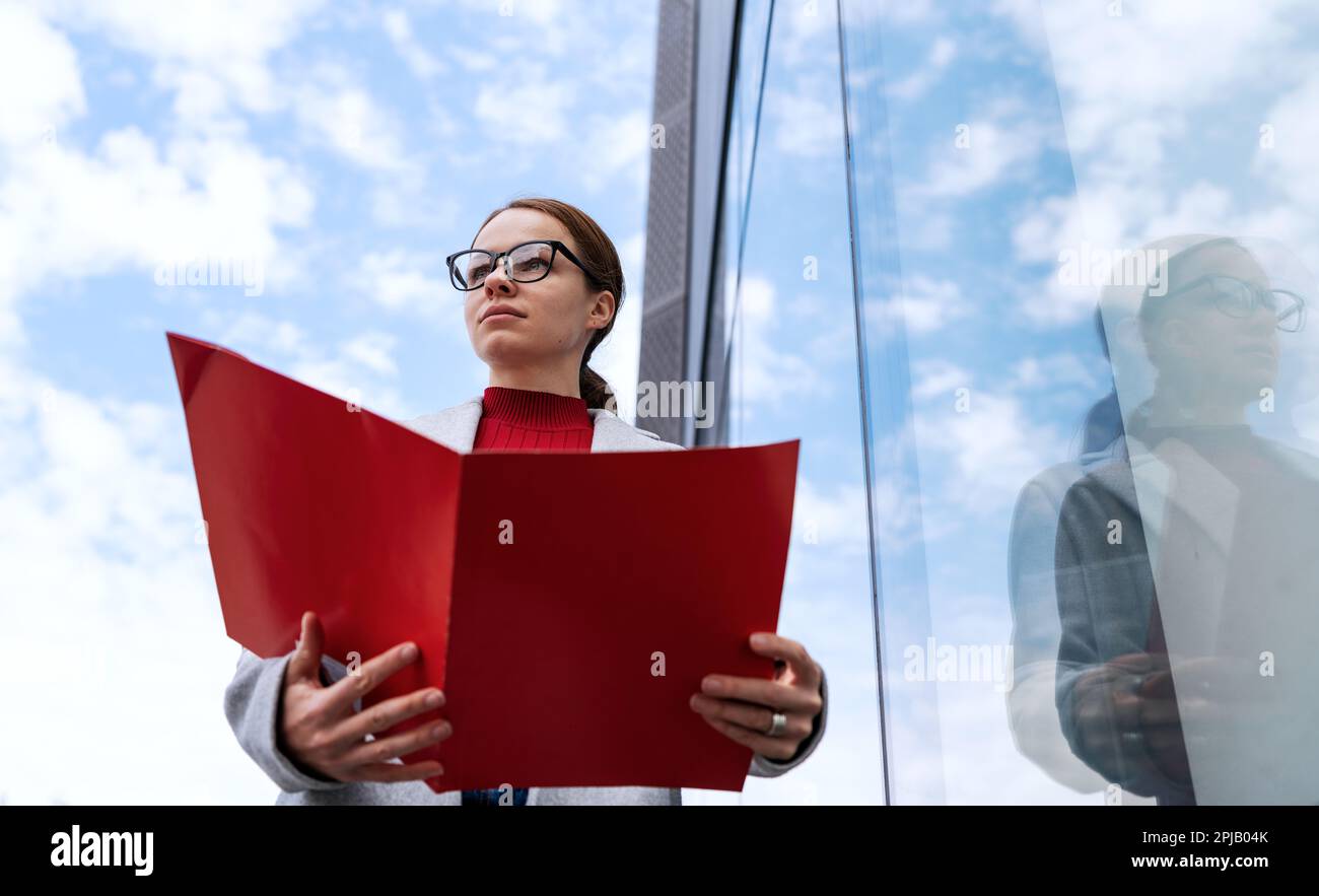 Administrative office worker, businesswoman with red folder in hands. Stock Photo