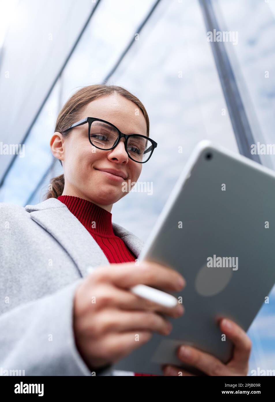 Female businessperson smiling while using het digital tablet and internet. Stock Photo