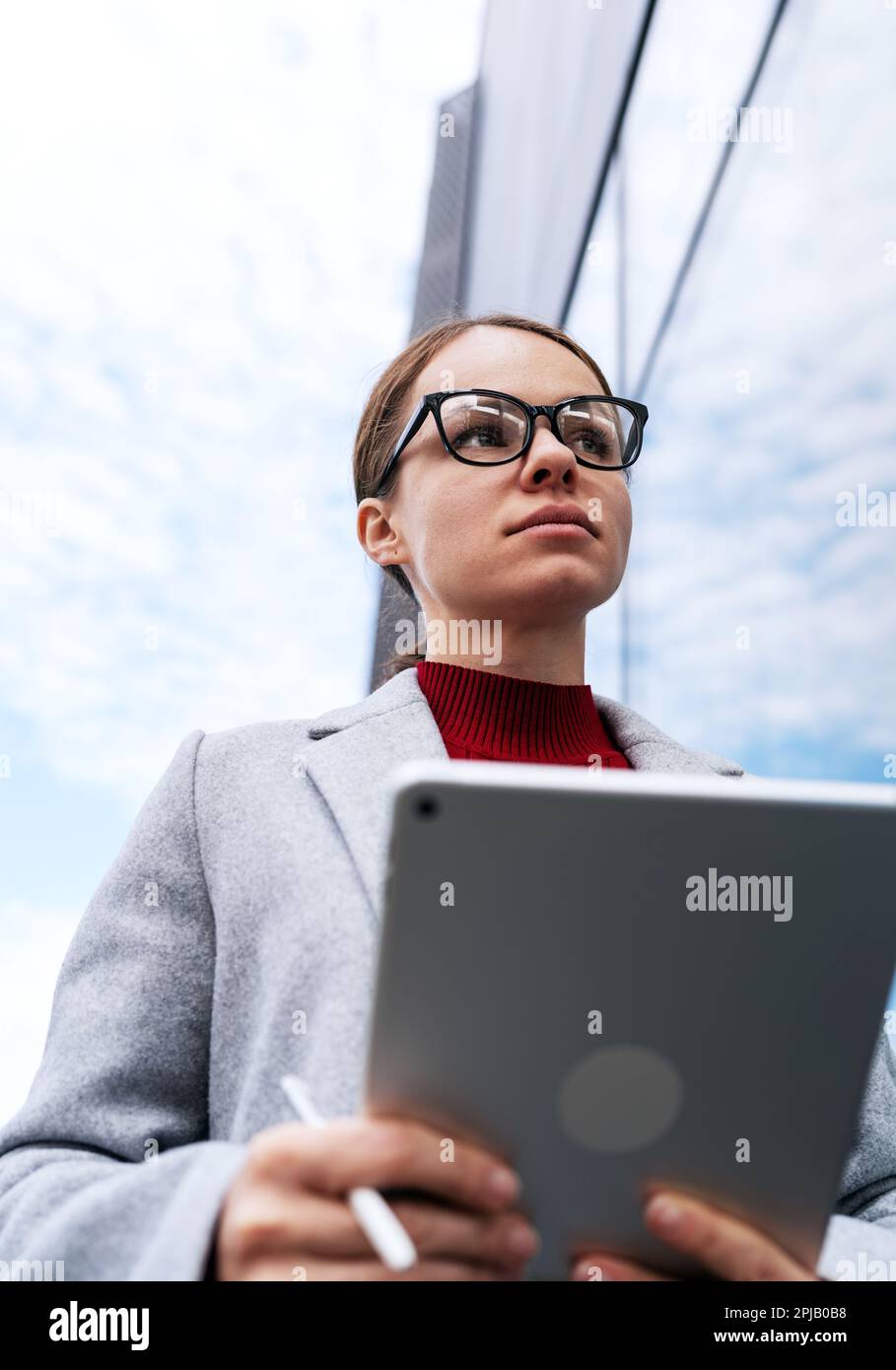 Businesswoman with digital tablet outside the office building. Stock Photo