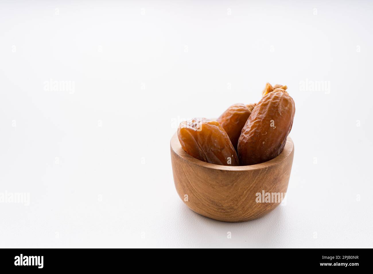 Dried dates fruit in wooden bowl isolated on white background Stock ...