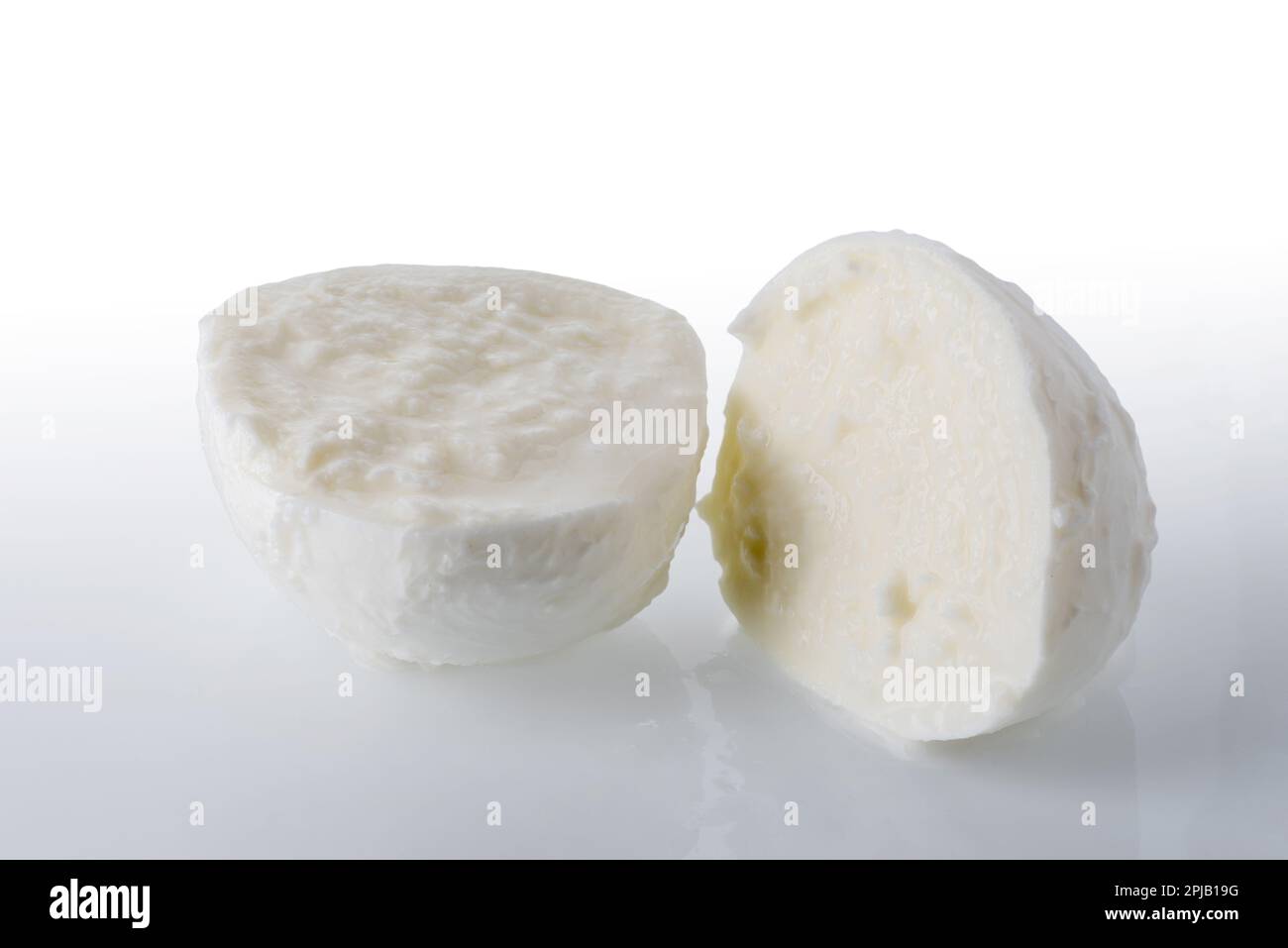 Mozzarella ball cut in half on white background; clipping path included