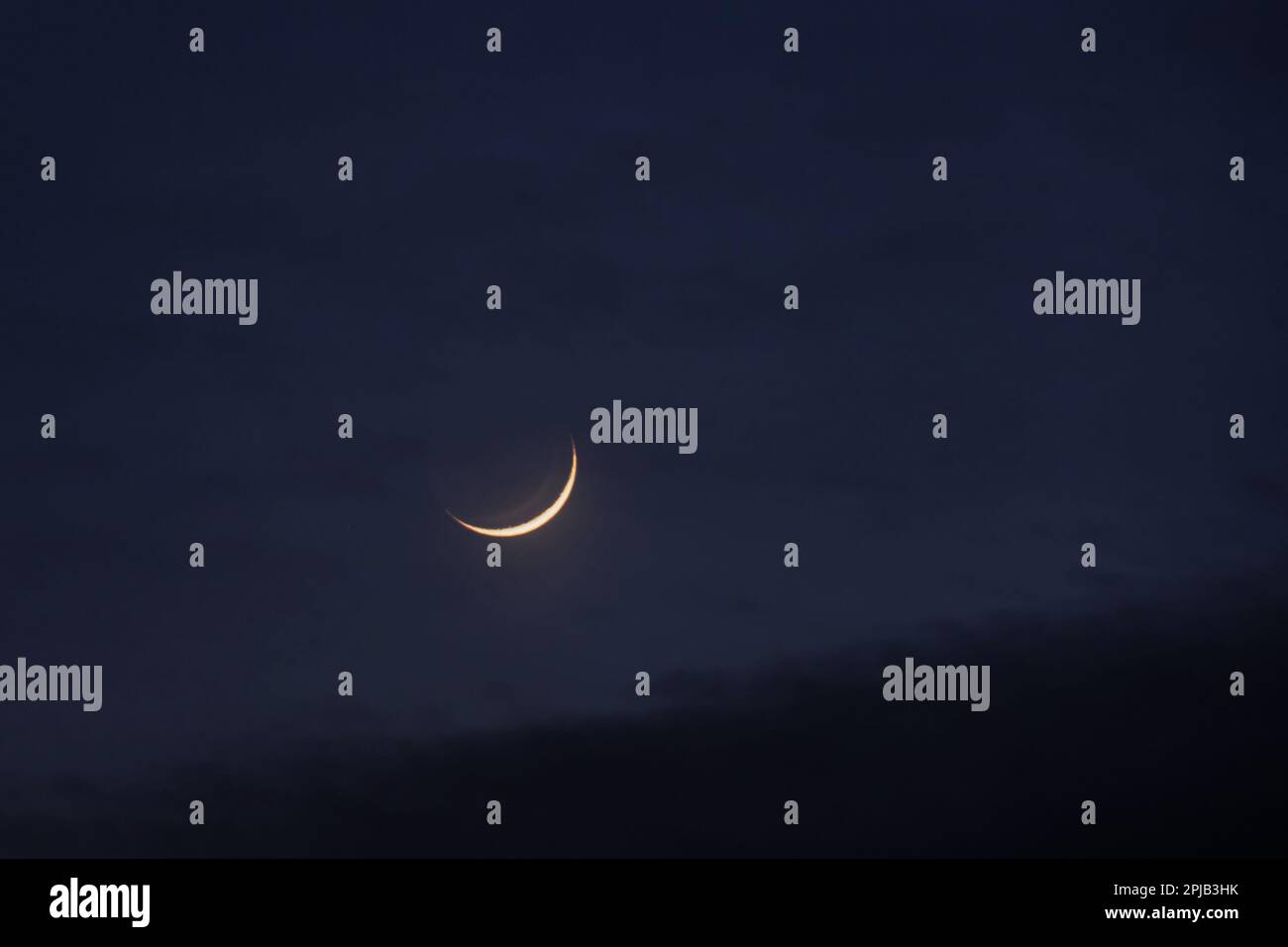 Young moon in the initial phase on a dark night sky Stock Photo