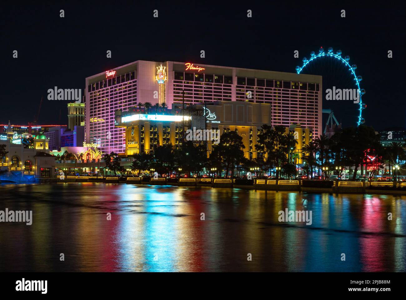 A picture of the Flamingo Las Vegas Hotel and Casino at night, reflected on the Bellagio Fountain. Stock Photo