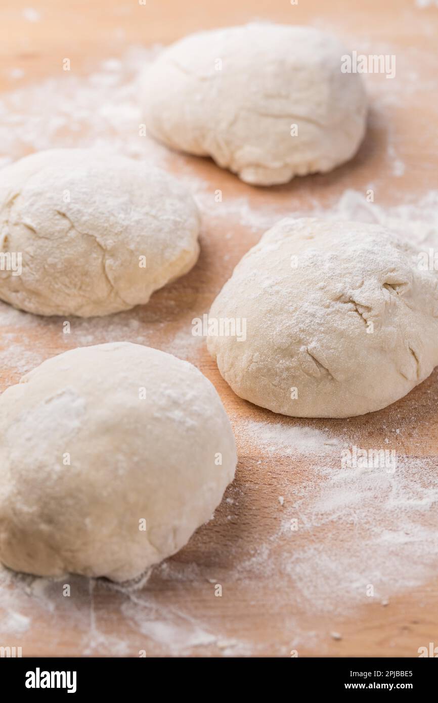 Freshly prepared yeast dough for pizza or bread on wooden background. Home cooking concept Stock Photo