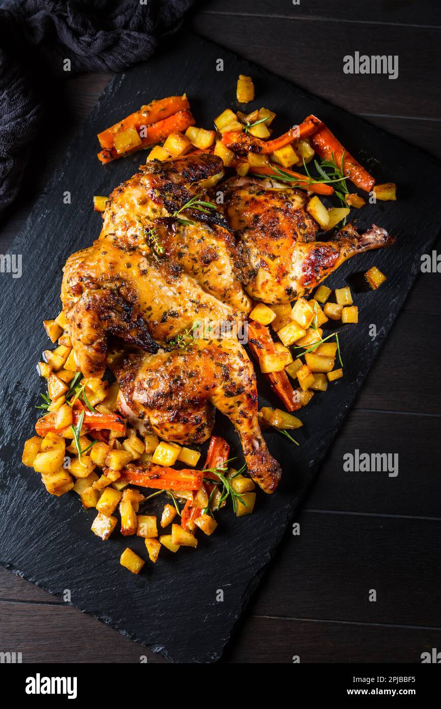 Butterflied grilled whole chicken with roasted vegetables and potatoes
