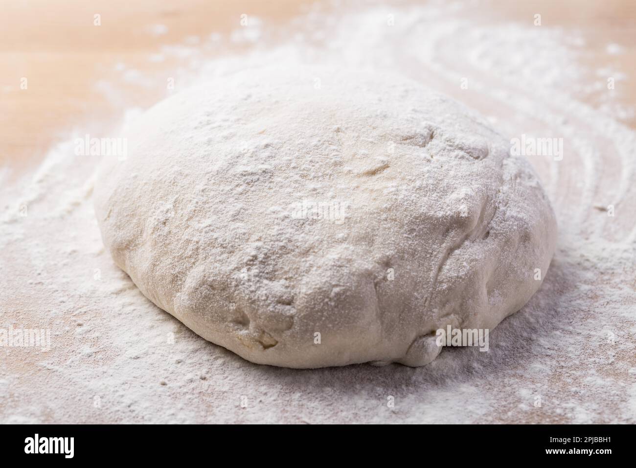 Homemade yeast dough freshly prepared for pizza or bread on wooden background. Home cooking concept Stock Photo