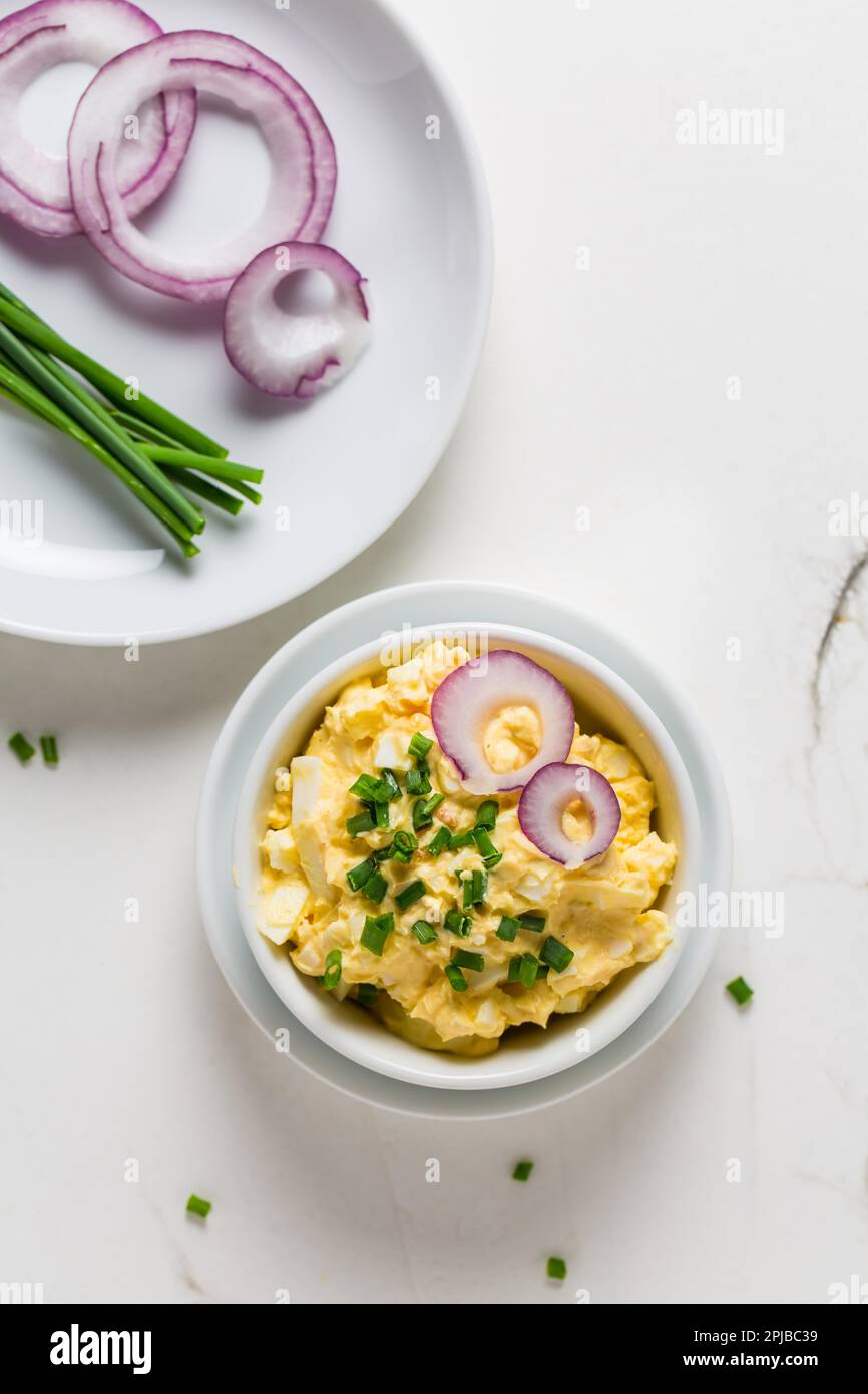 Egg spread with onion and chives on marble background Stock Photo