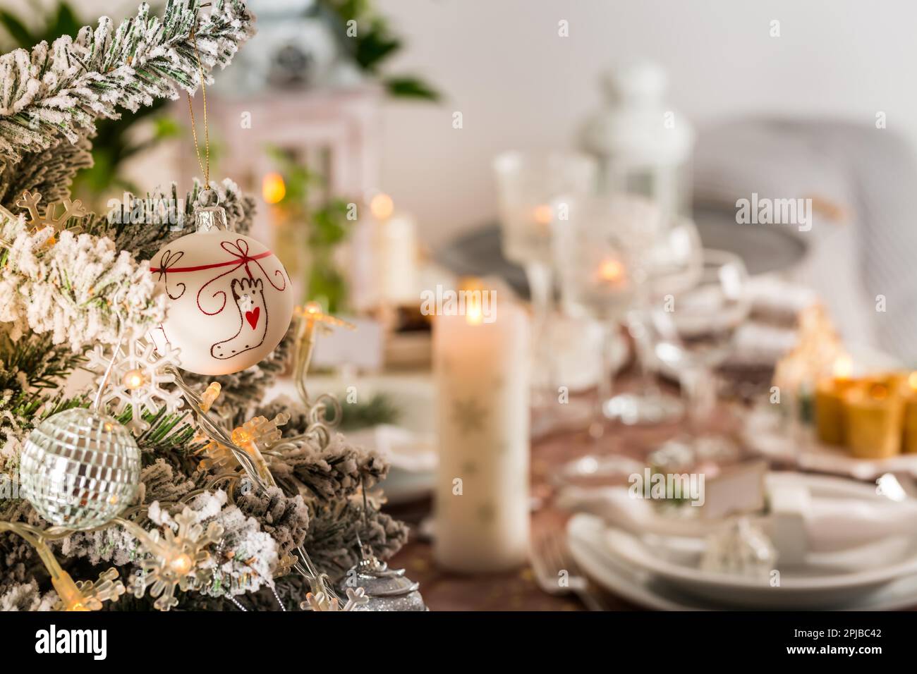 Table setting for celebration Christmas and New Year Holidays. Festive table at home with Christmas tree Stock Photo