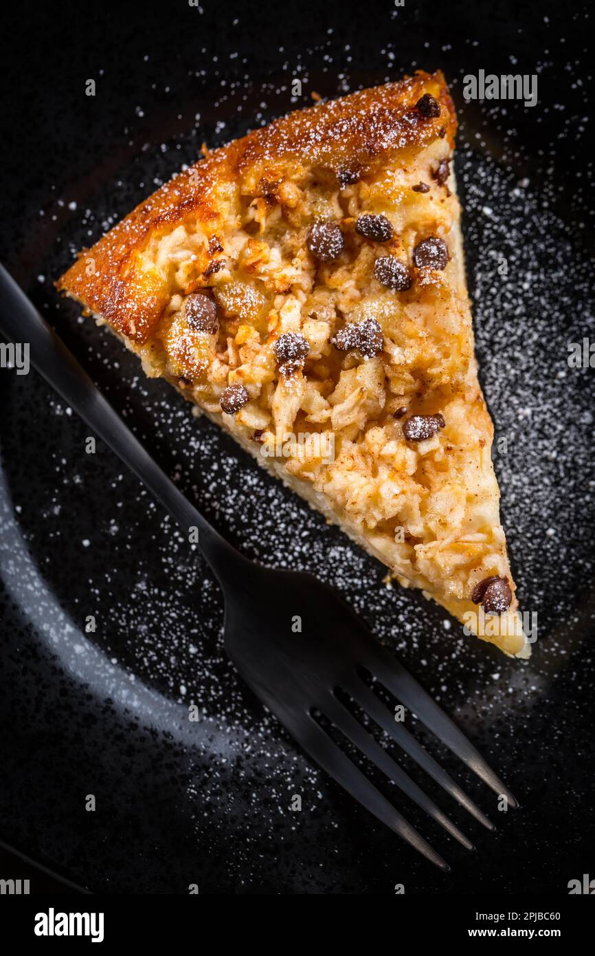 Piece of homemade apple pie with chocolate pieces for Thanksgiving on black plate Stock Photo