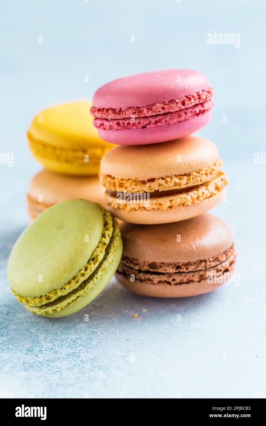 Assorted delicious French macarons on blue background Stock Photo