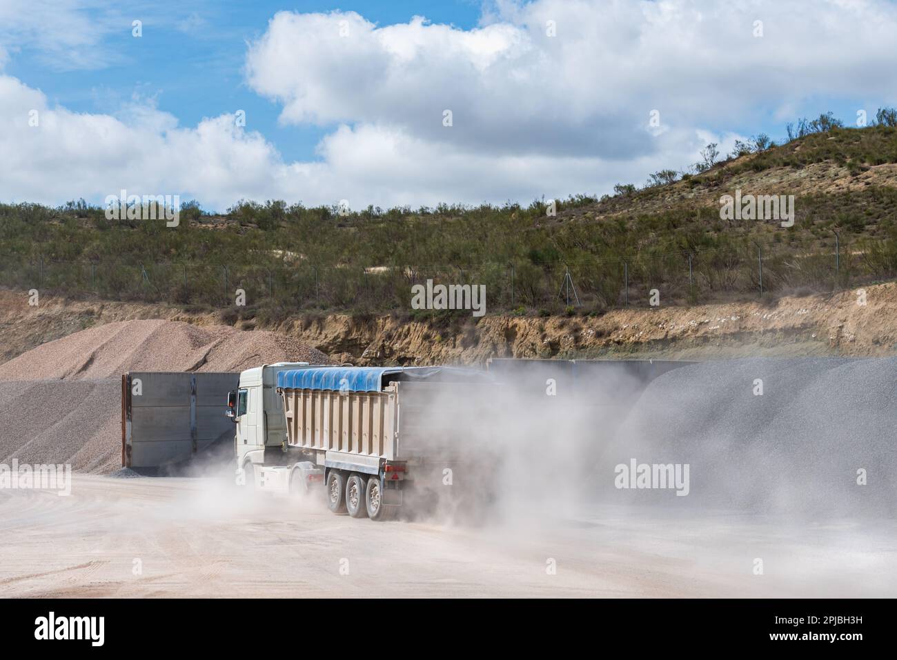 Tump truck entering a arid quarry. Stock Photo