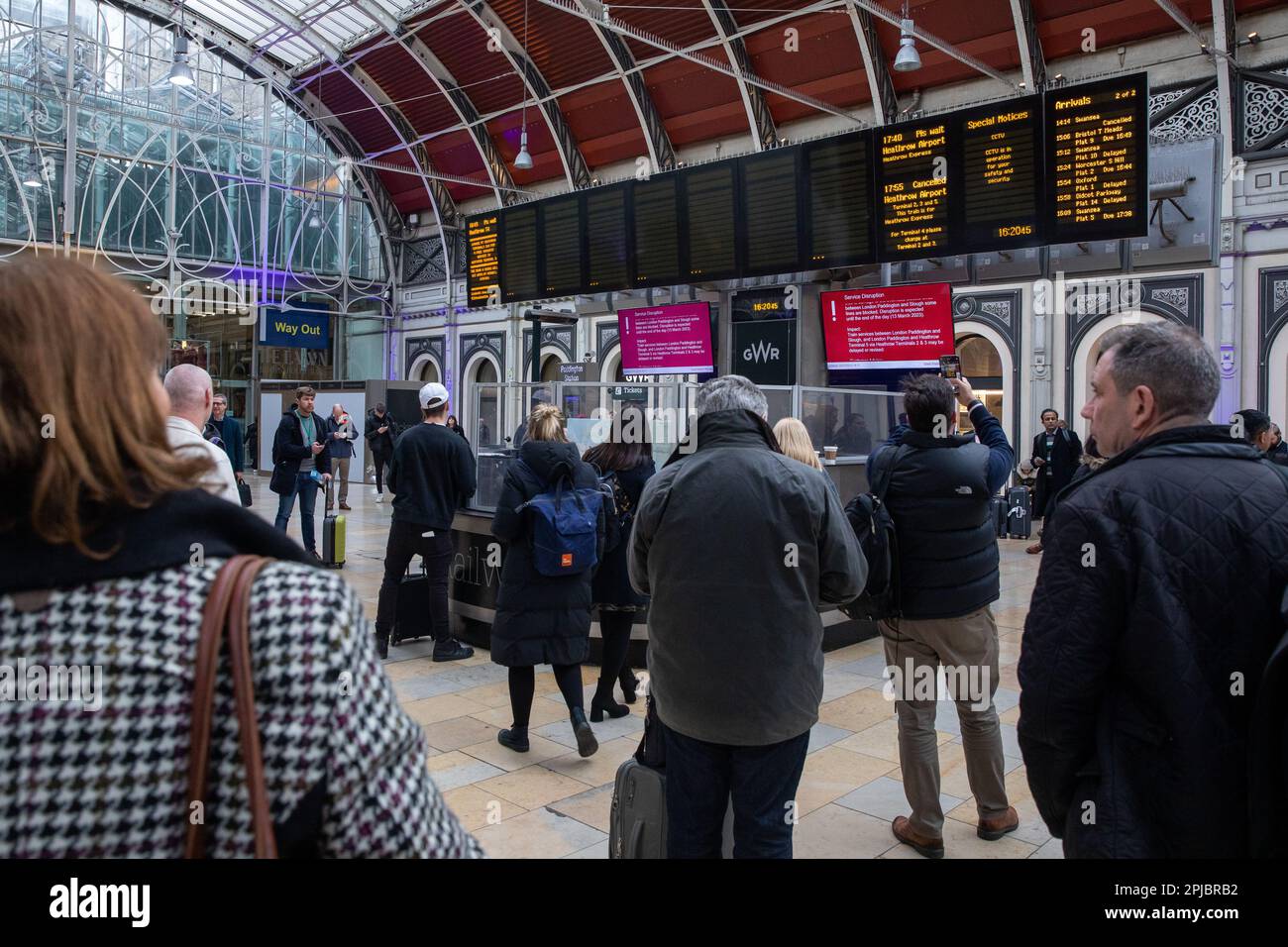 London, UK. 13th March, 2023. Commuters view a live departure board at ...