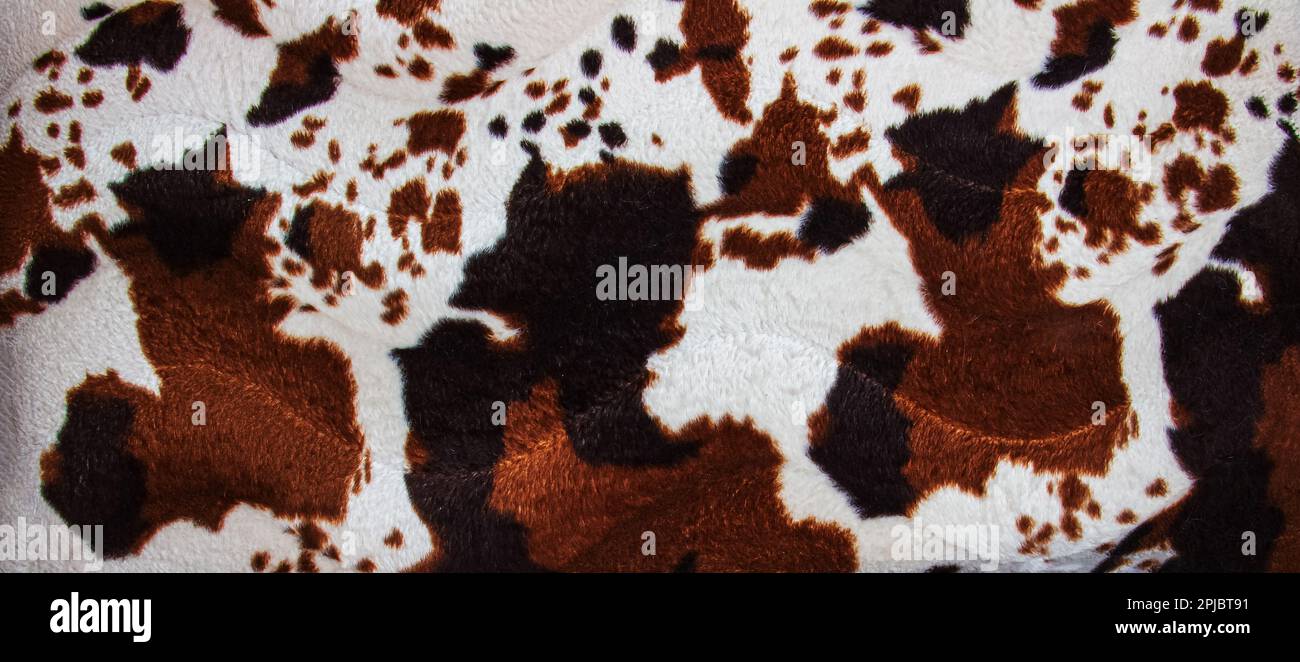Texture of faux leopard fur with brown spots. Background of artificial