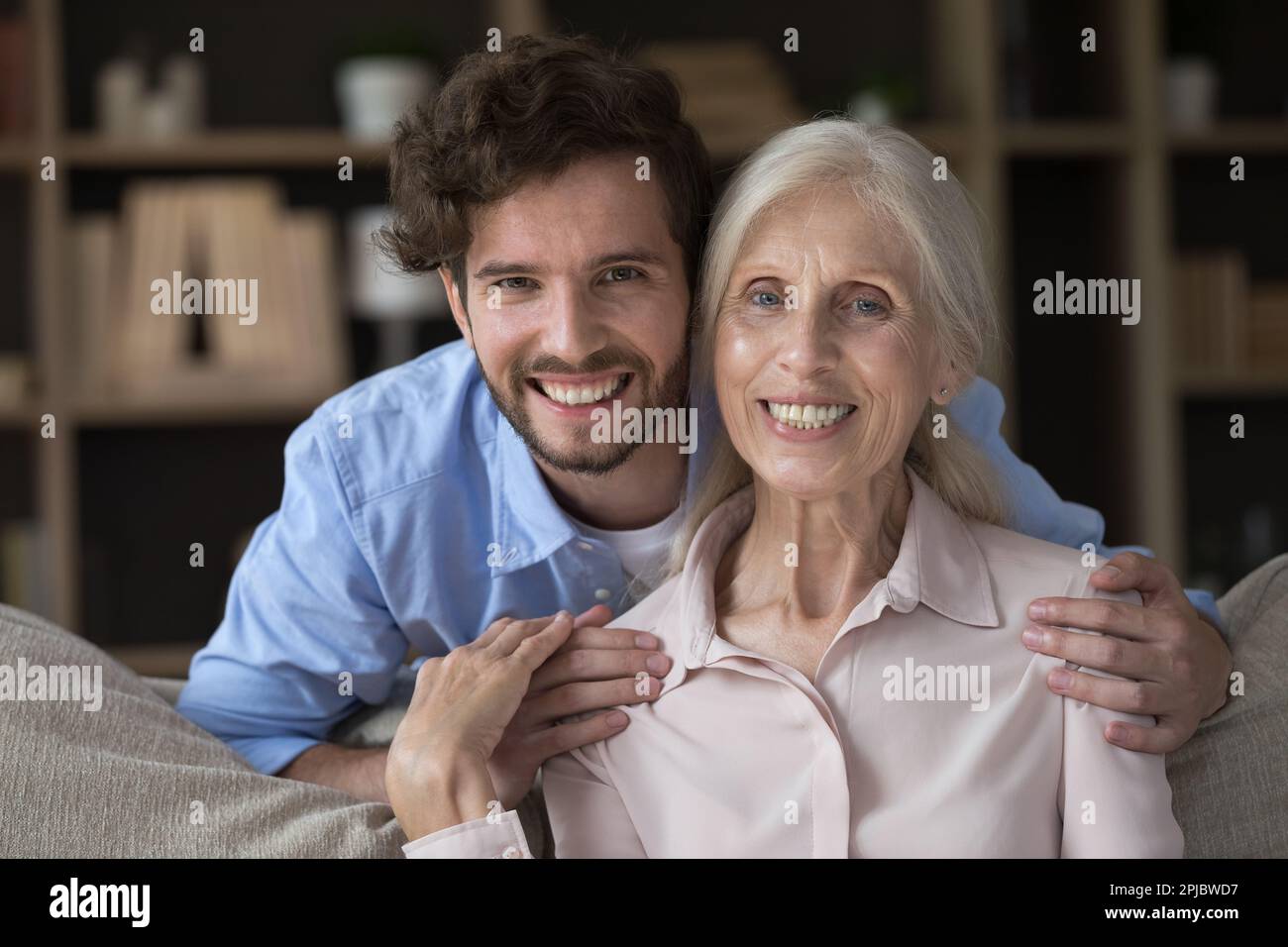Happy caring handsome grandson guy hugging elder pretty grandma Stock ...