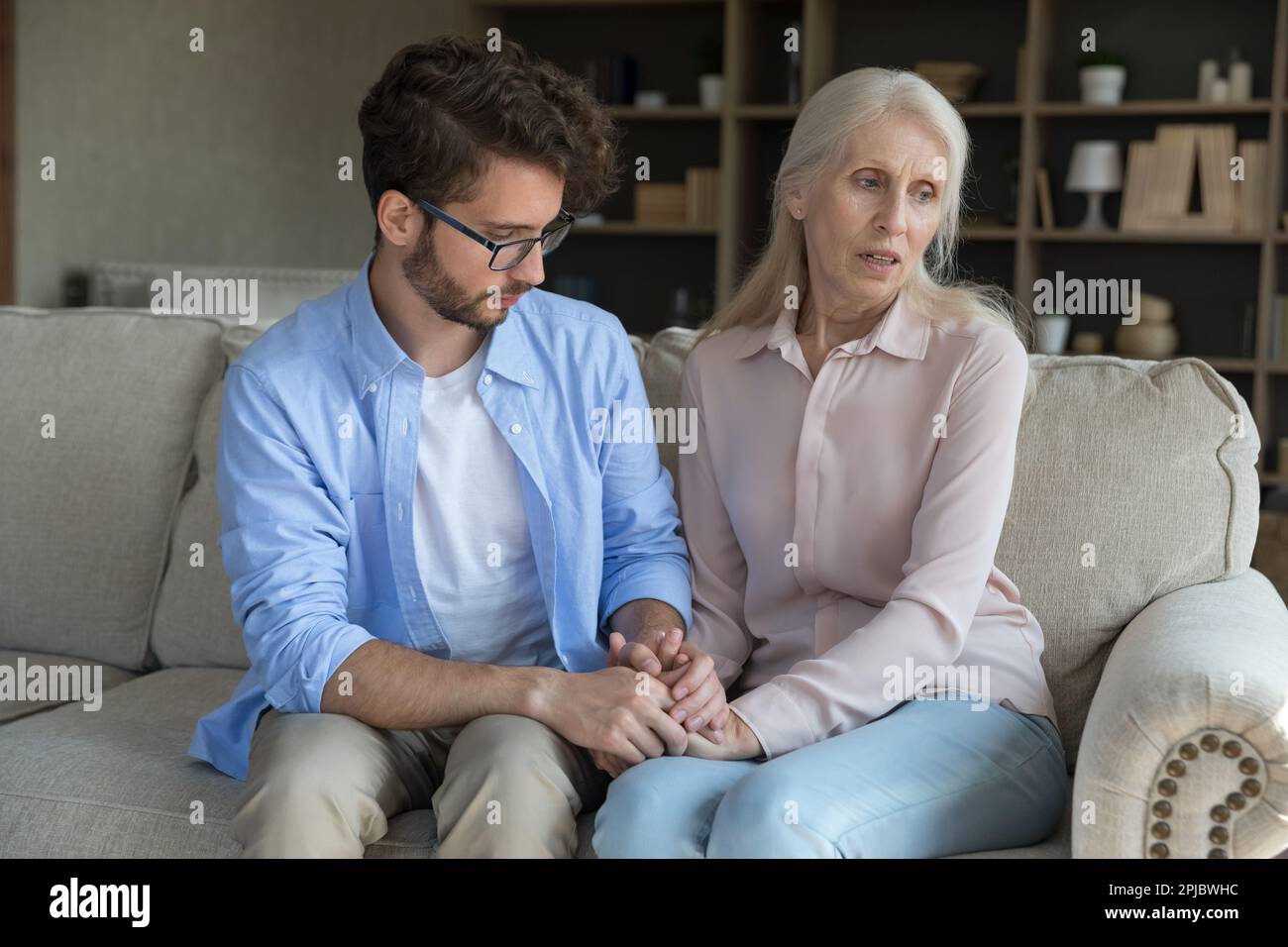 Loving adult son comforting worried concerned senior mother Stock Photo - Alamy