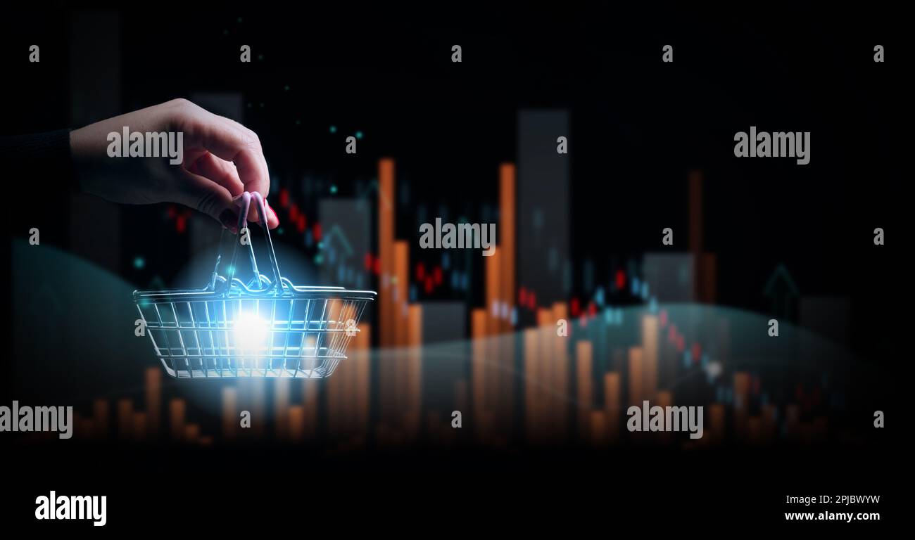 A female hand holding a miniature shopping basket and a chart with