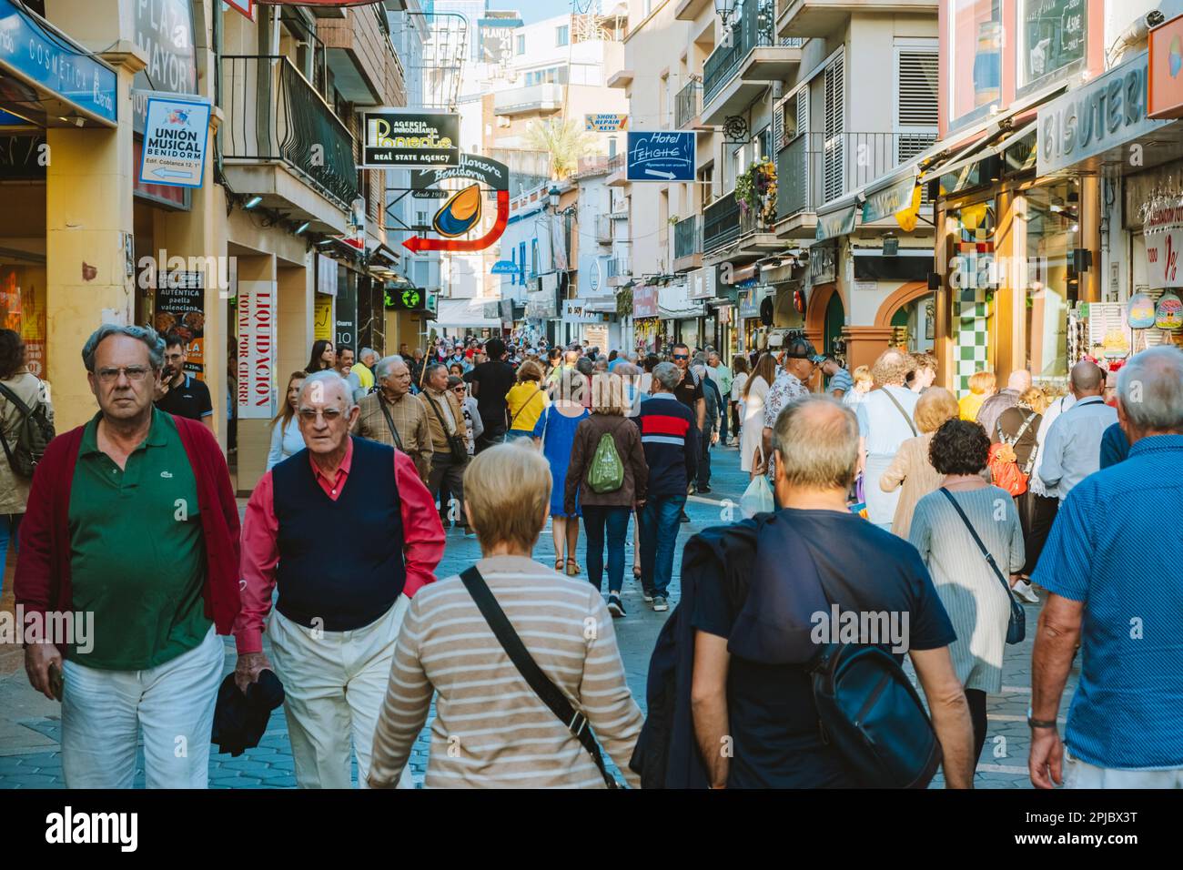 Benidorm, Spain - 01 April, 2023: People walking and enjoy sunny day on the shopping street in Benidorm old town. Crowdy streets of Benidorm. Benidorm Stock Photo