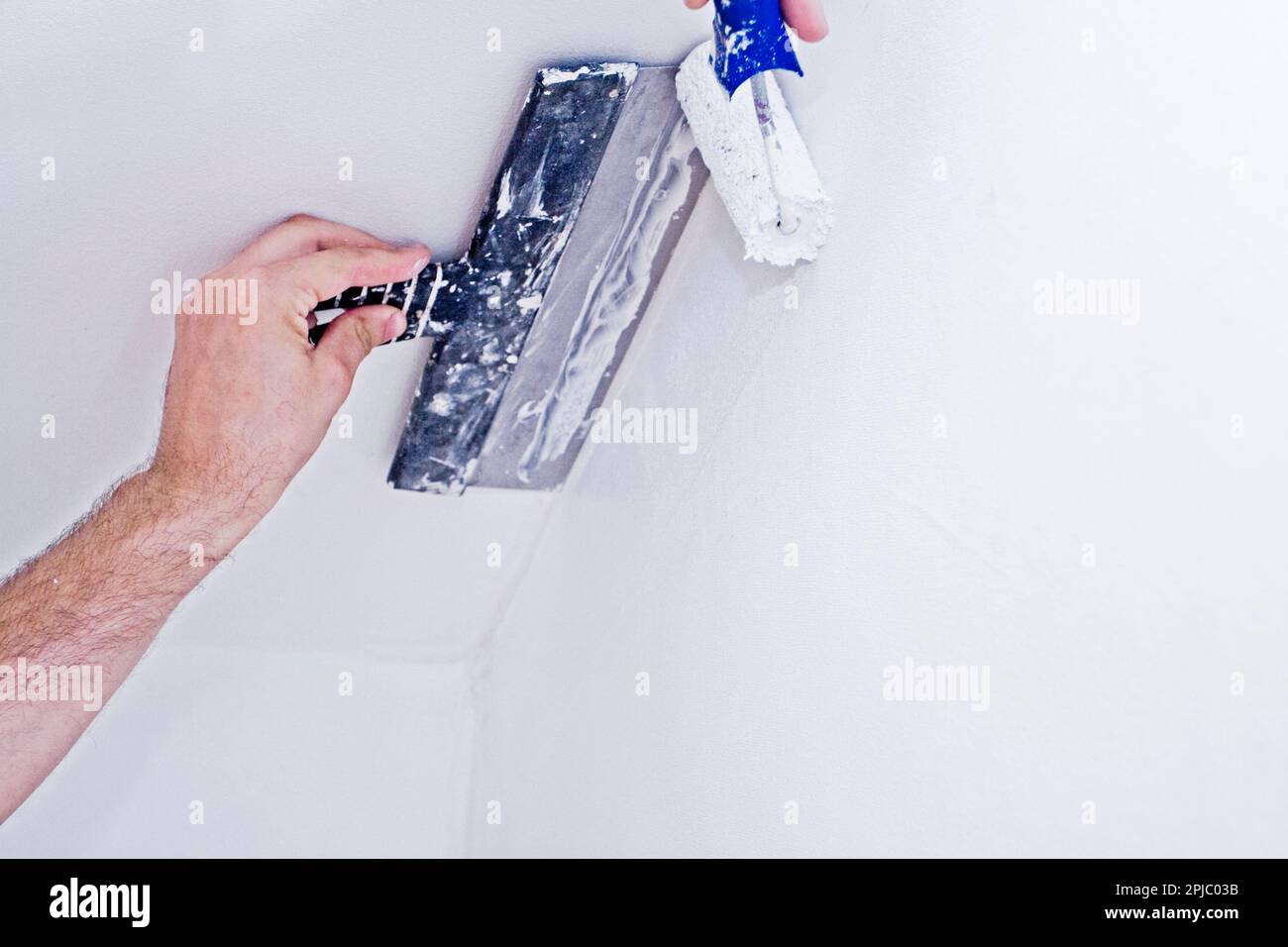 paint the walls with white paint and a spatula Stock Photo