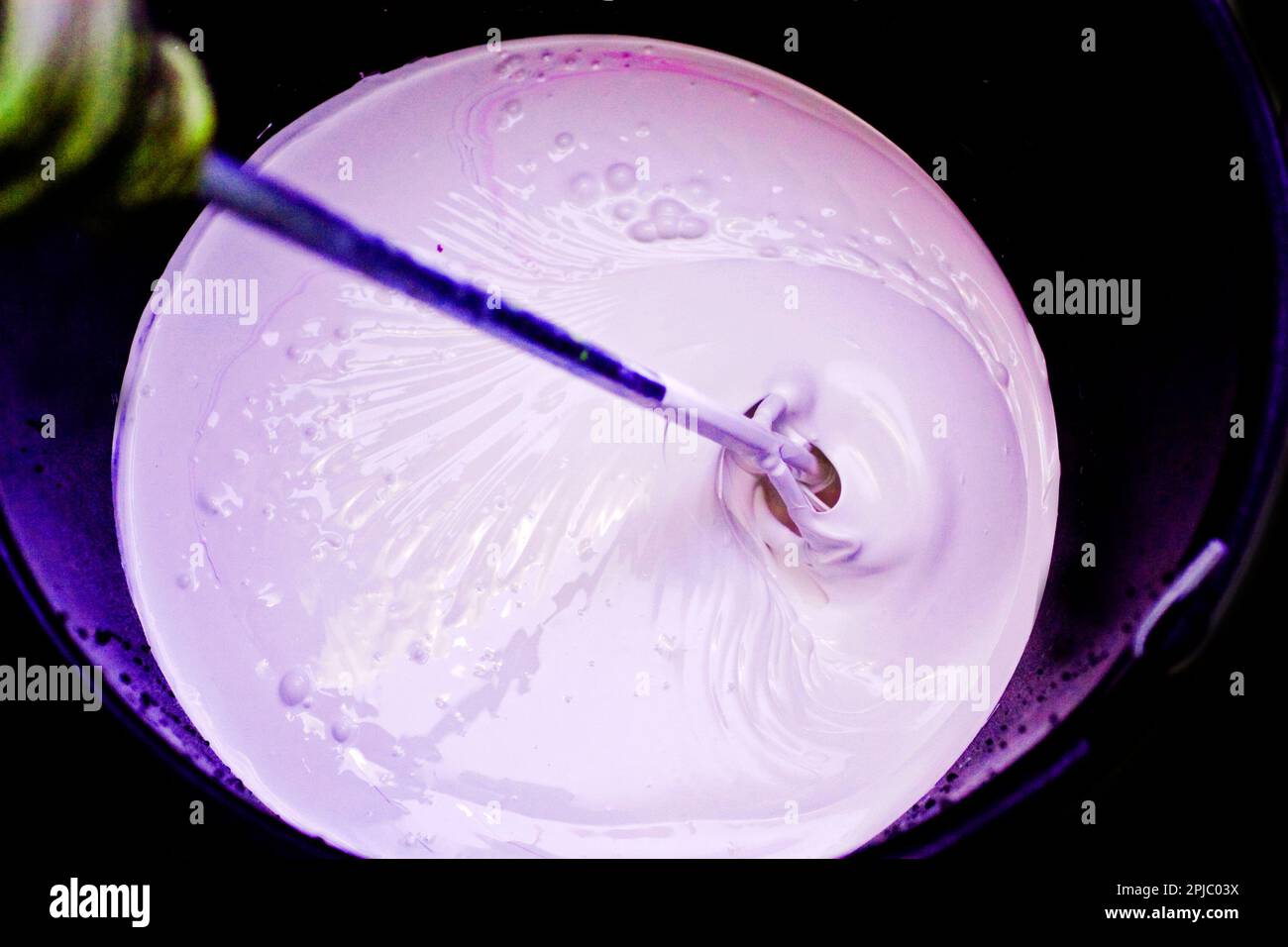 stir pink paint to paint the walls Stock Photo Alamy