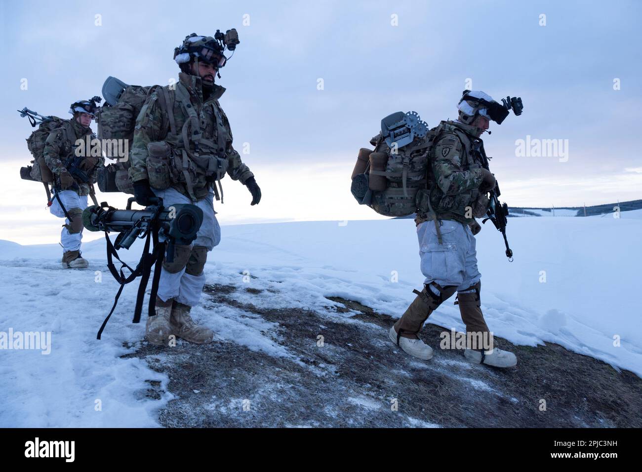 U.S. Army paratroopers with the 3rd Battalion, 509th Parachute Infantry Regiment, 2nd Infantry Brigade Combat Team (Airborne), 11th Airborne Division, make their way to the flightline before conducting an air assault mission during Joint Pacific Multinational Readiness Center-Alaska 23-02 at Ladd Army Airfield, Fort Wainwright, Alaska, March 30, 2023. JPMRC-AK 23-02 helps Soldiers and leaders develop and refine the tactics, techniques, and procedures necessary to successfully operate in remote and extreme Arctic winter conditions and overcome environmental and military challenges. Army aviator Stock Photo