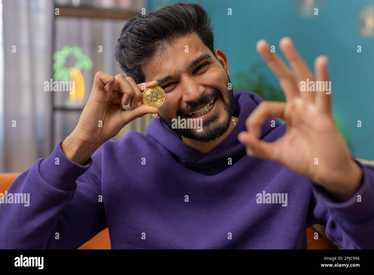 Indian man freelancer holding gold coin successful developer programmer.  Ok. Hindu guy stock trader earning bitcoins after online monitoring trading  operations. Increasing wealth financial prosperity Stock Photo - Alamy