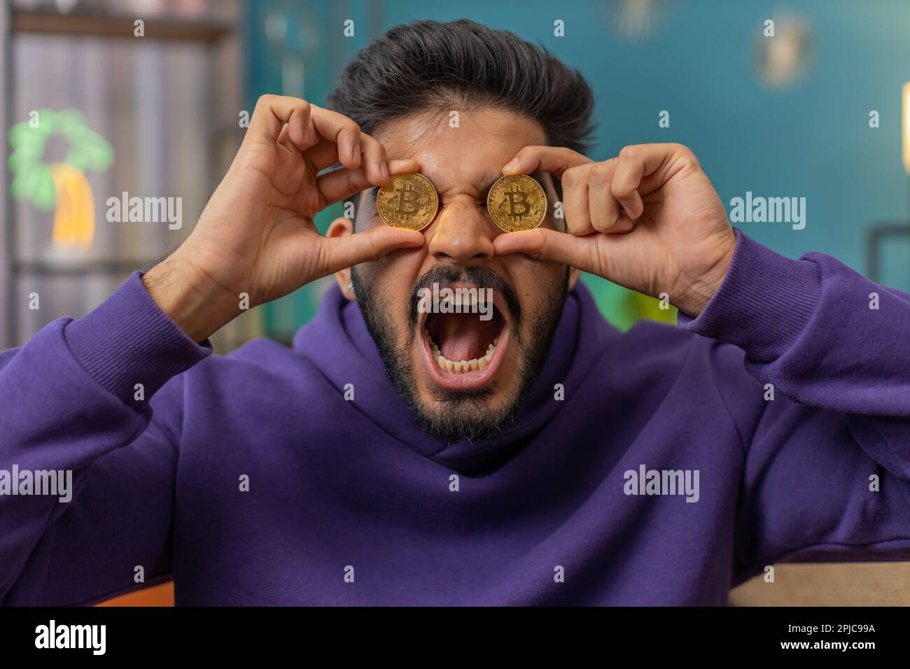 Indian man freelancer holding two gold coins successful developer programmer.  Hindu guy stock trader earning bitcoins after online monitoring trading  operations. Increasing wealth financial prosperity Stock Photo - Alamy
