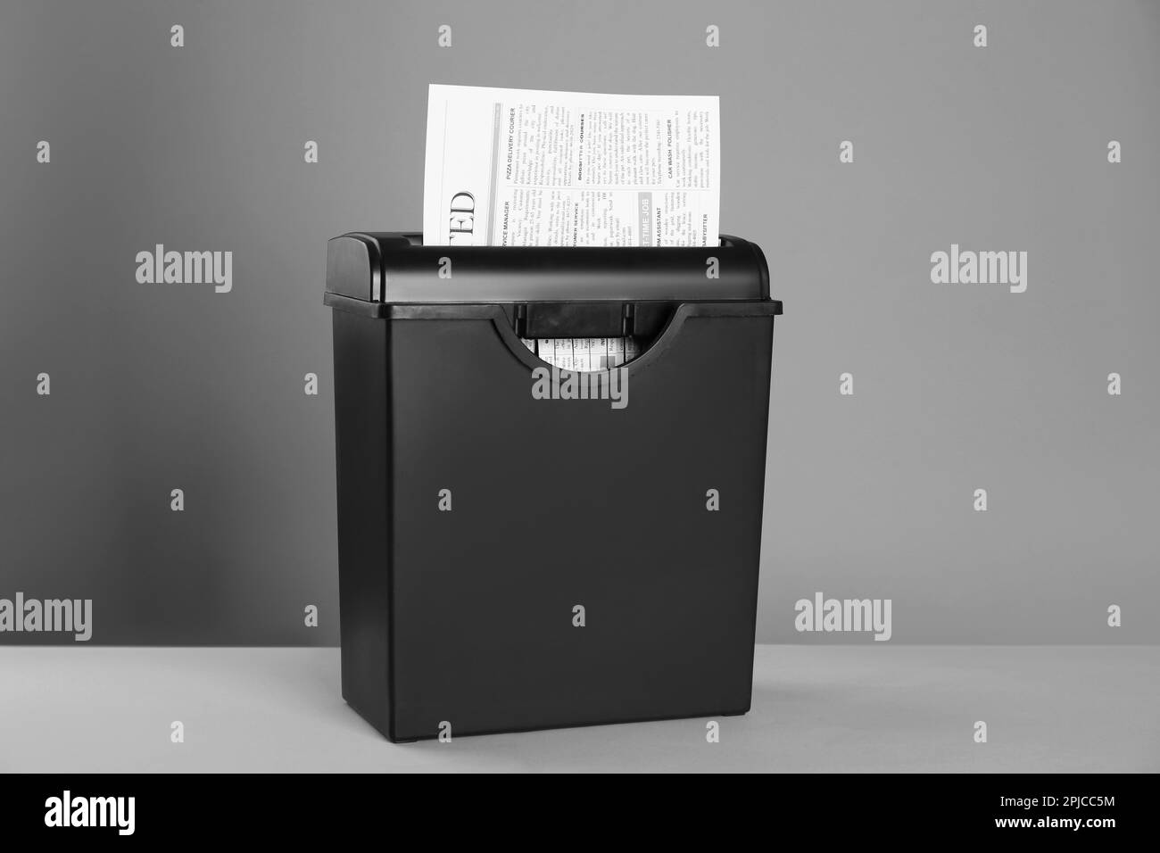 Paper shredder with newspaper on color background Stock Photo Alamy