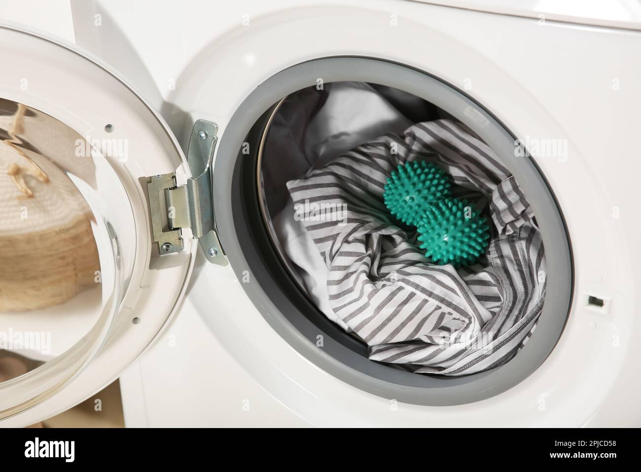 Green dryer balls and clothes in washing machine drum Stock Photo - Alamy