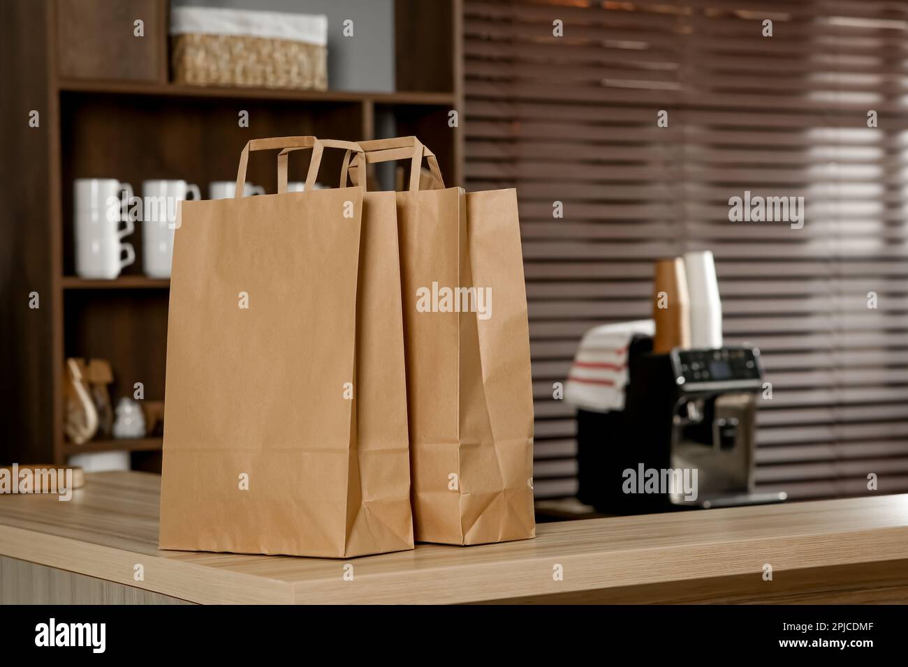 Paper bag on wooden counter in cafe, space for text Stock Photo - Alamy