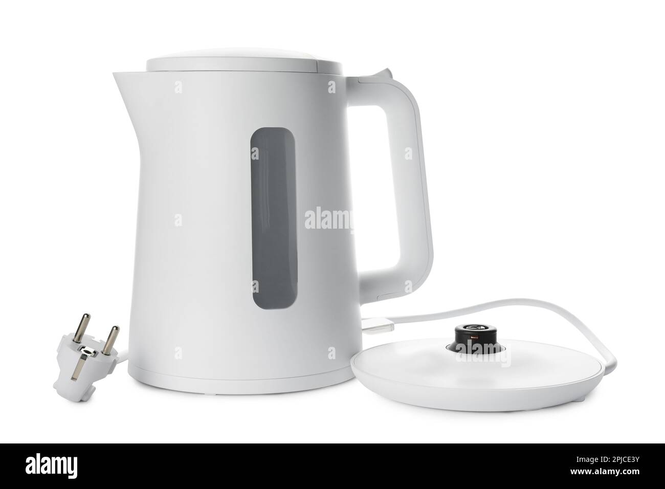 White electric kettle stands on a gray table plugged into a power outlet  Stock Photo - Alamy