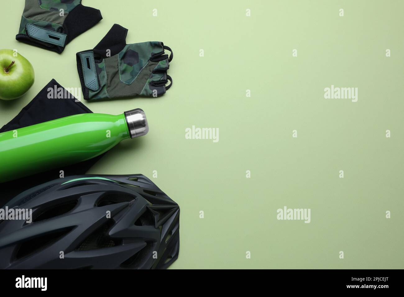 Flat lay composition with different cycling accessories and clothes on light background, space for text Stock Photo