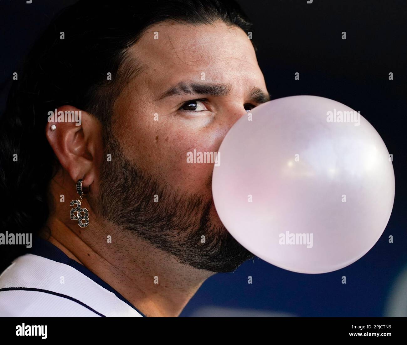 Seattle Mariners' Eugenio Suarez blows a bubble in the dugout