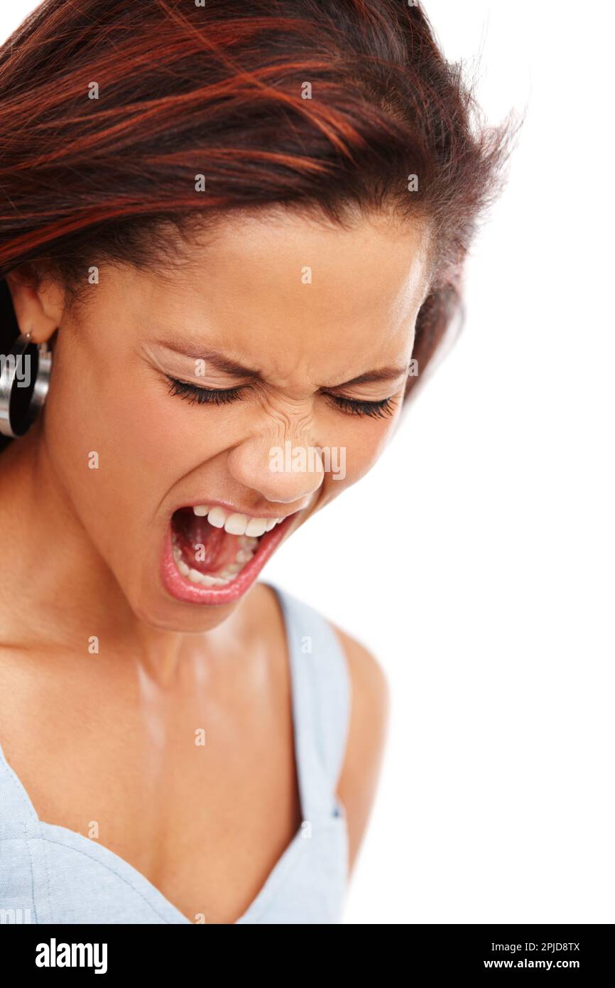 Letting it all out. A young woman screaming loudly while isolated on a white background. Stock Photo