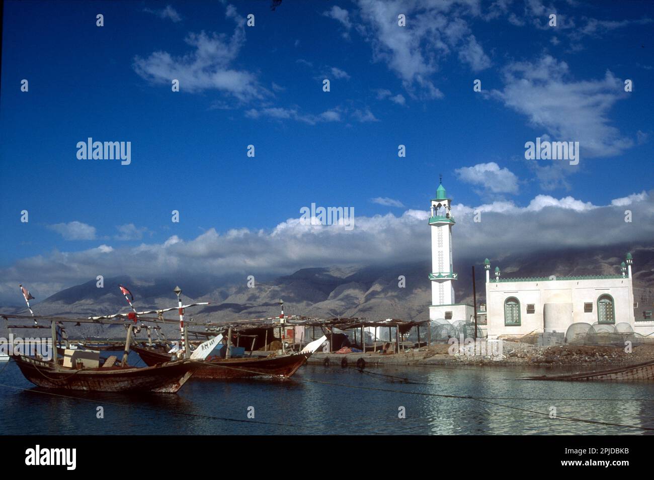 Fishing dhows moored beside a newly built mosque, development in Rams, suburb of Ras al Khaimah, UAE, 2002 Stock Photo