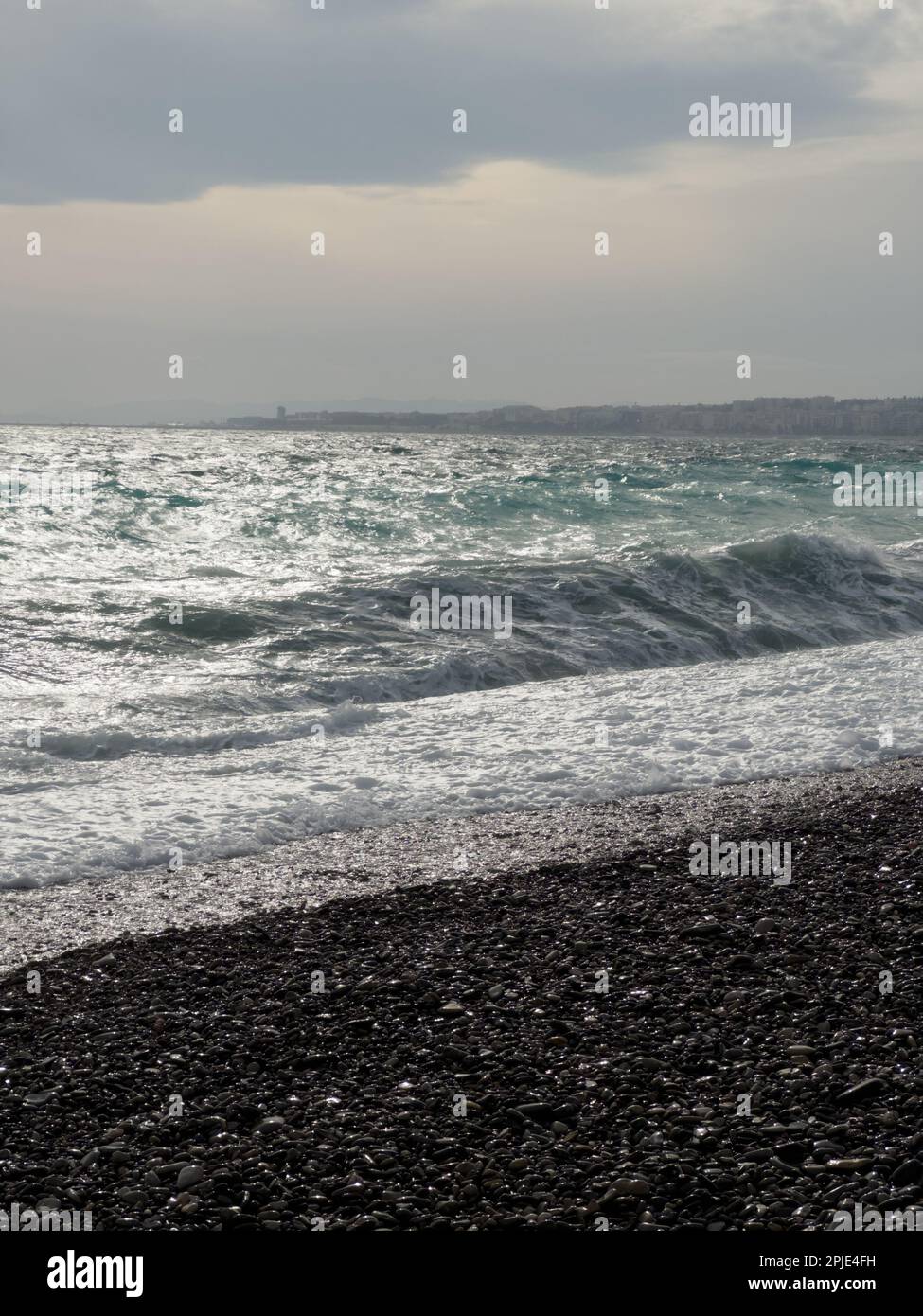 Pebble beach of Nice, France with azure waves of mediterranean sea ...